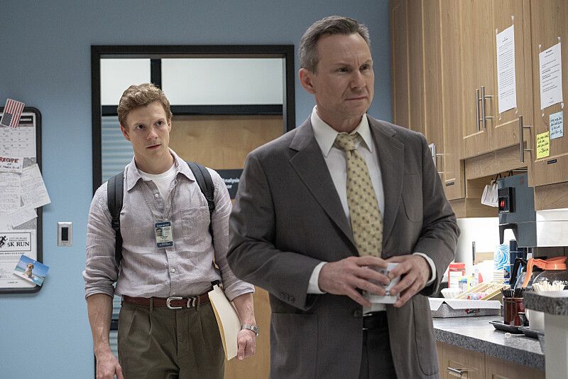 younger man and older man in suit in office