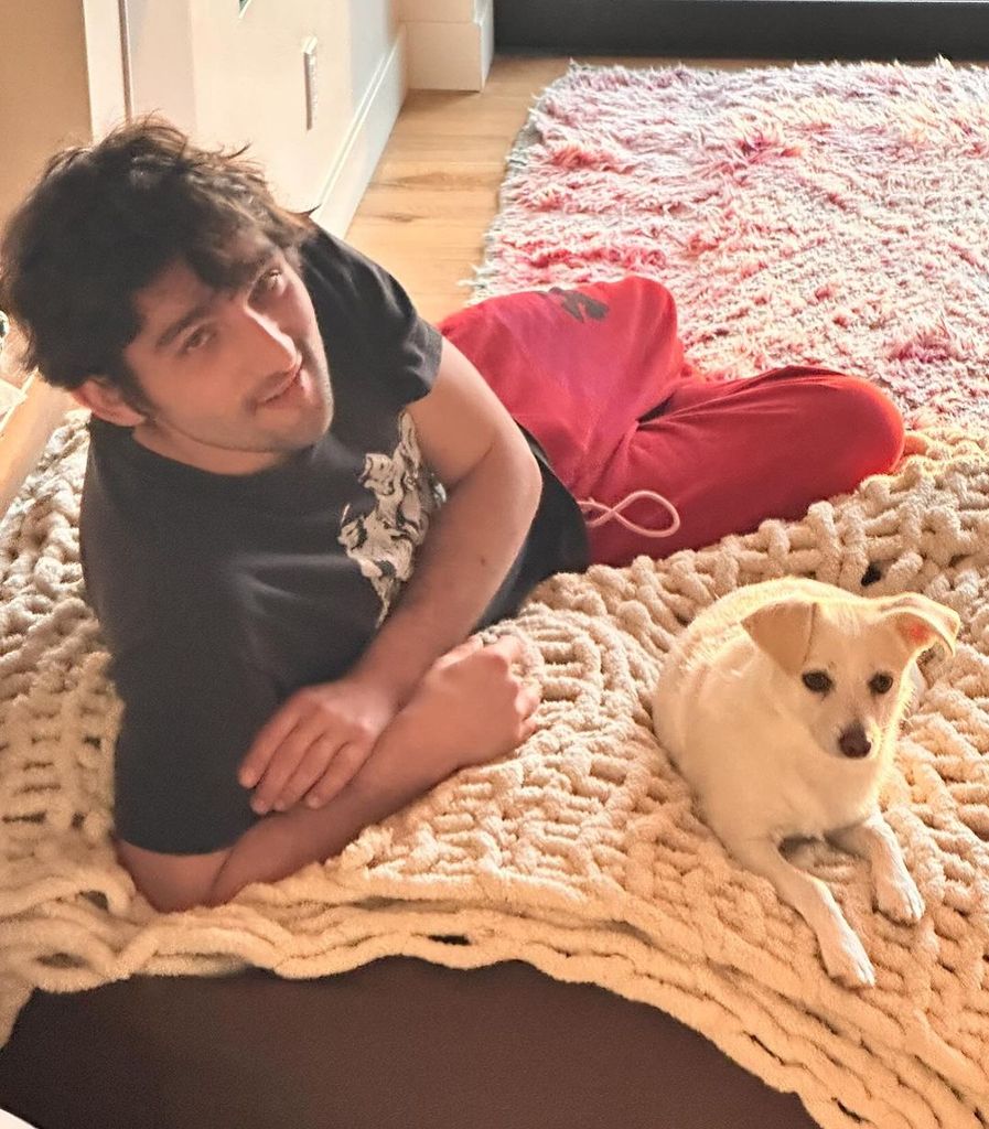 Ricki Lake's son Milo lies on a rug with Dolly the dog