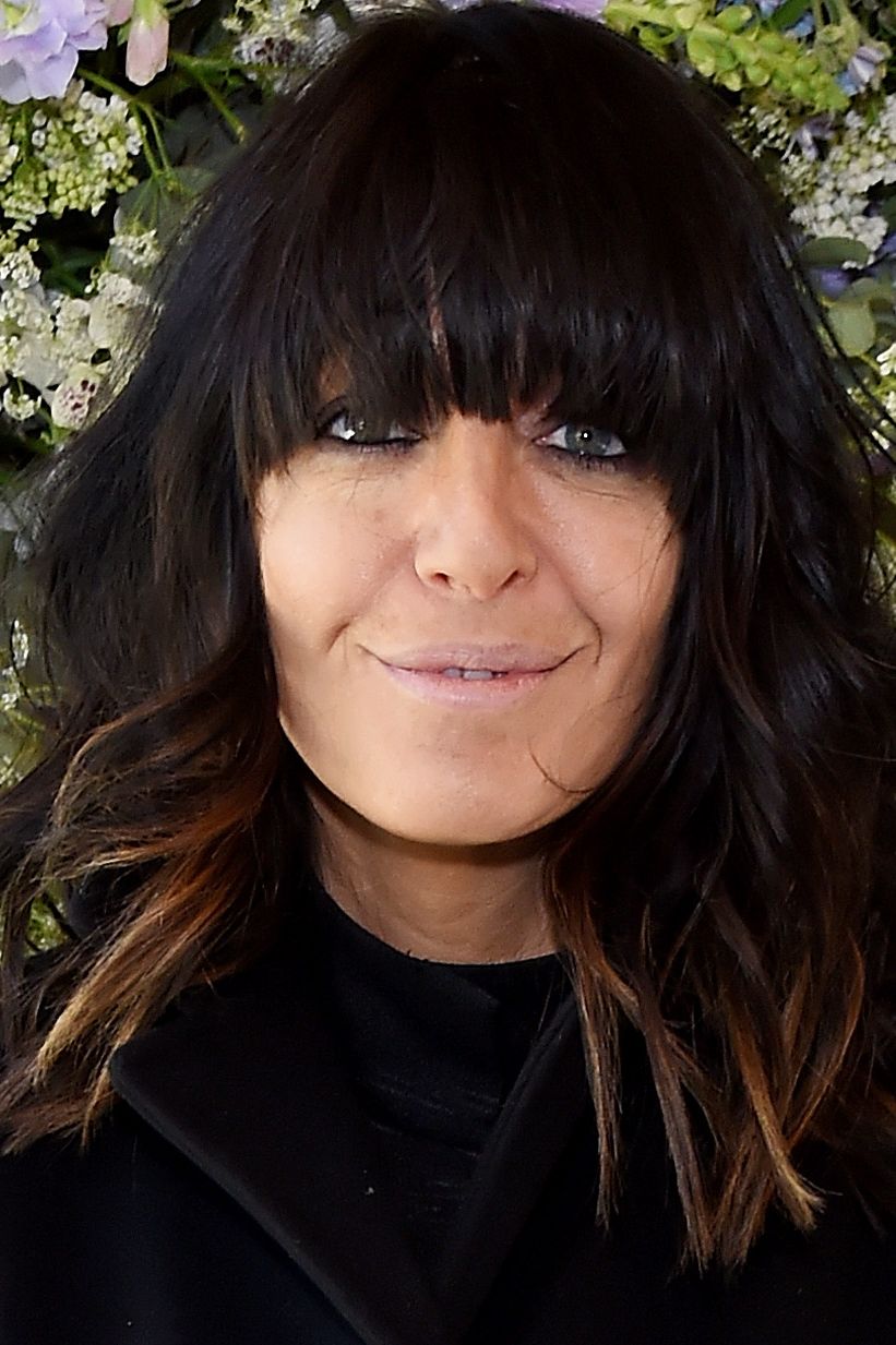 Claudia Winkleman in a black outfit with flowers in the background