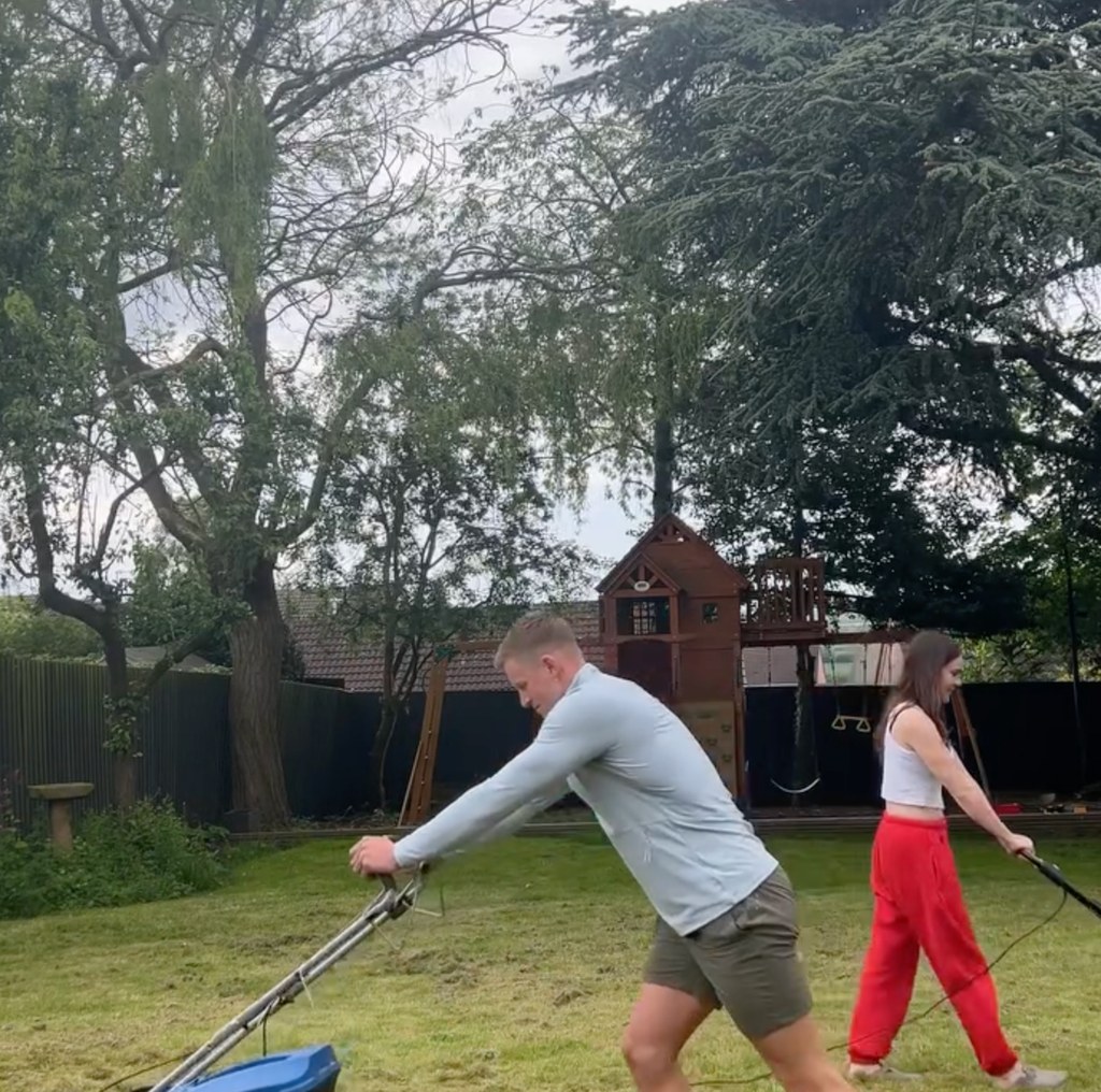 two people mowing a garden lawn