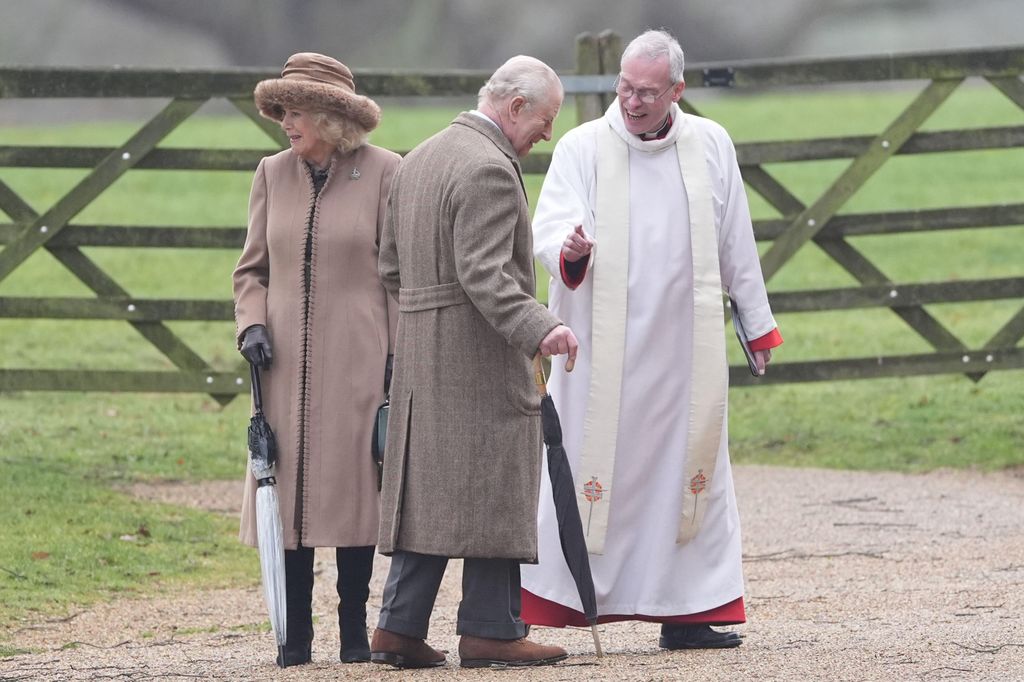 King Charles and Queen Camilla talking to vicar outside in coats