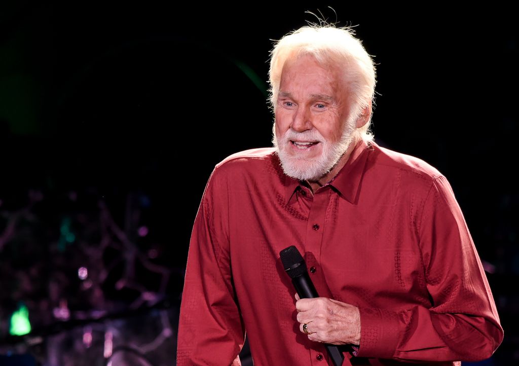 Kenny Rogers holding a microphone