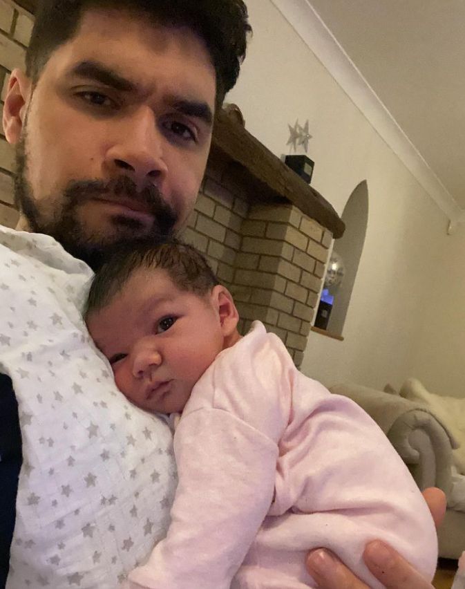 Louis Smith cradling a baby girl