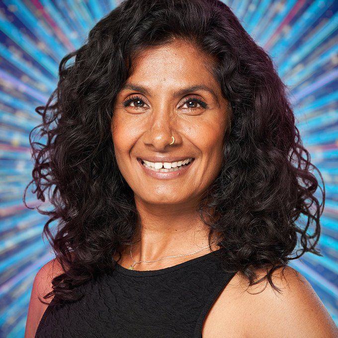 close-up of brunette woman smiling against blue background