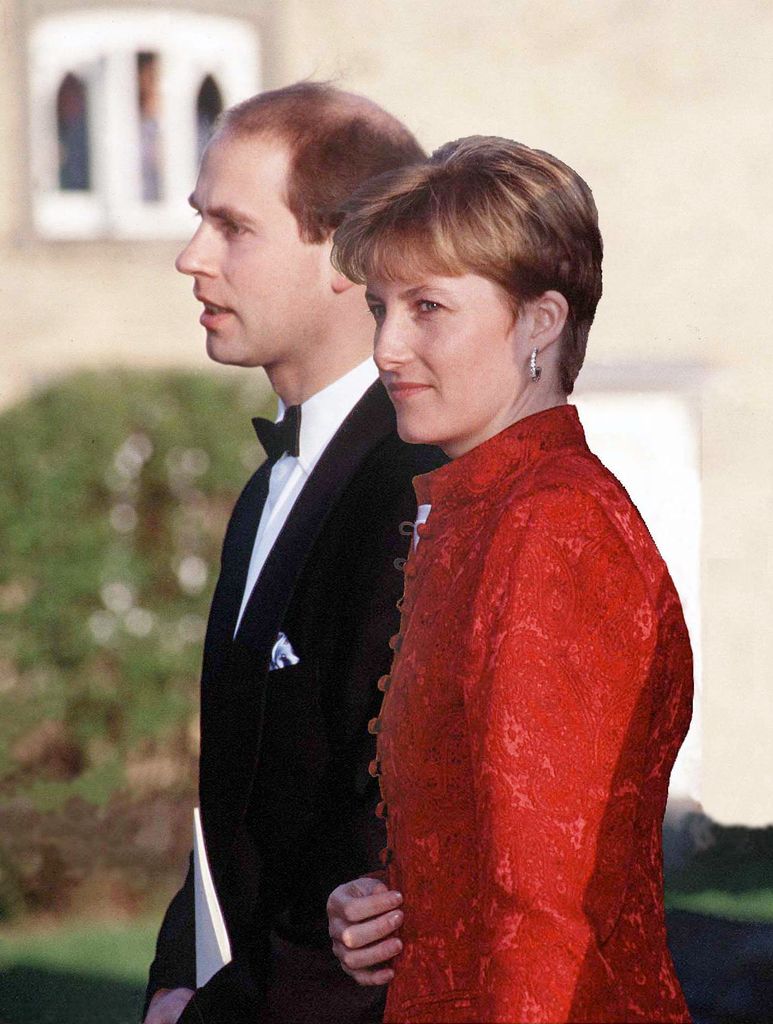 Prince Edward in a bow tie with Sophie Rhys-Jones in a red jacket attending a wedding