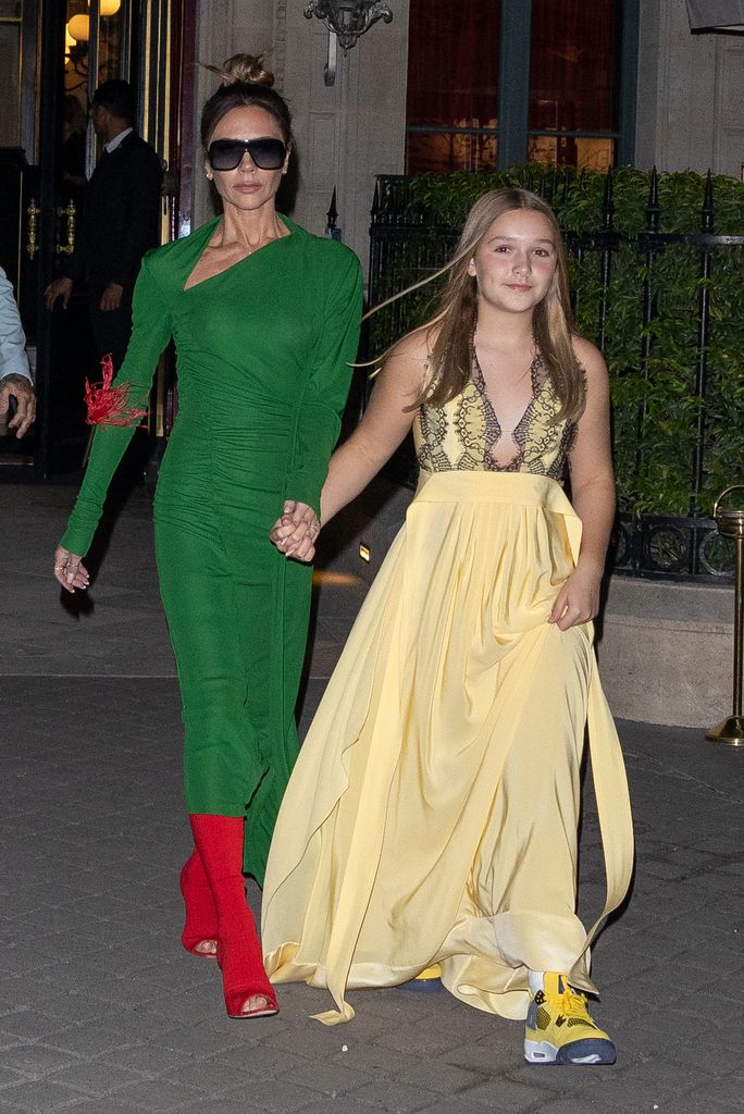 Harper wore a flowing yellow gown with yellow sneakers, walking beside Victoria Beckham in a green dress. Her bold shoe choice added youthful playfulness to the elegant eveningwear.