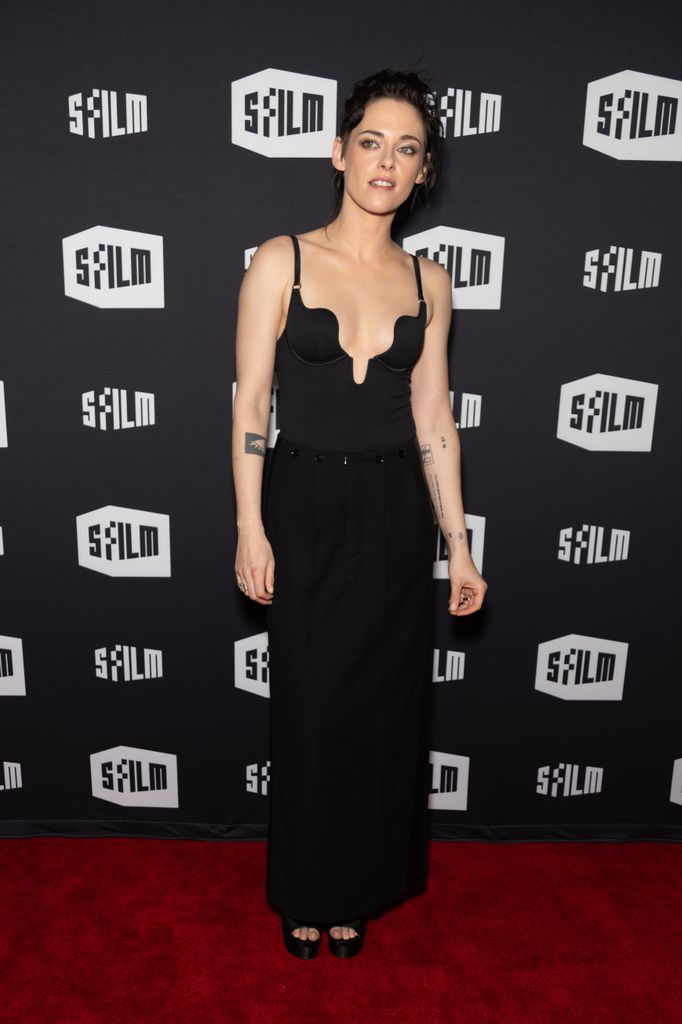Kristen Stewart on the red carpet wearing a black bustier teamed with a long black skirt