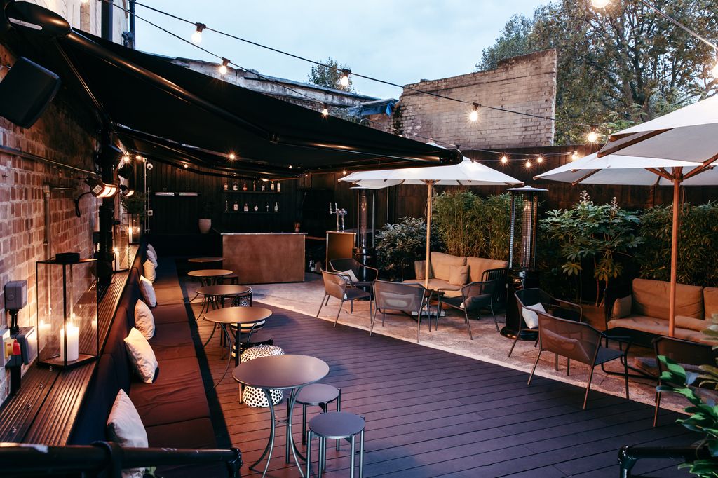 The outdoor seating area of the bar decorated with fairylights 