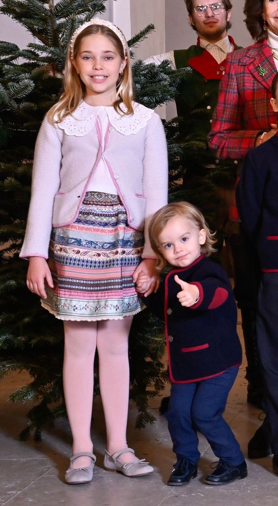 Prince Julian putting his thumb up in front of the Royal Palace's Christmas trees