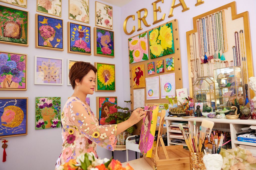 Helen painting in her studio, surrounded by beautiful artwork