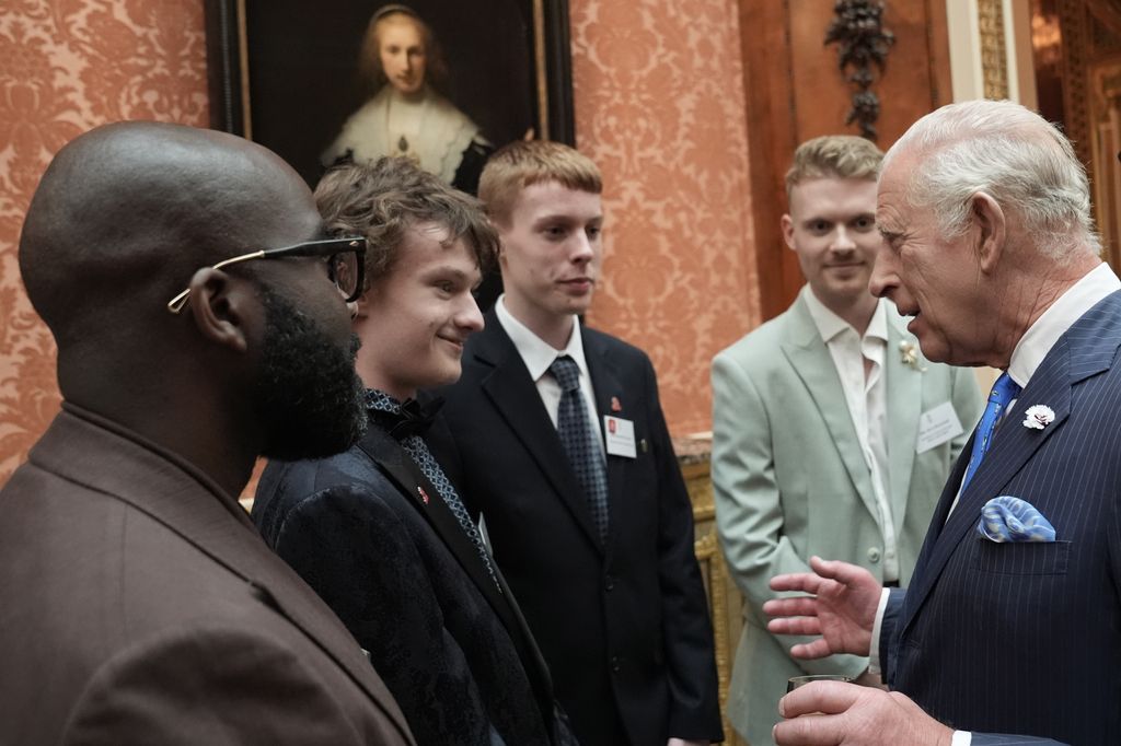 King Charles shaking hands with a group of young men
