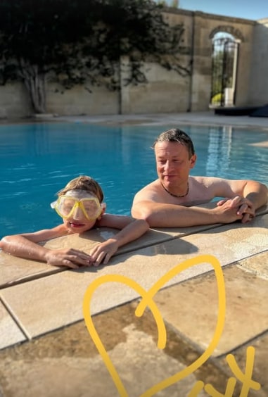 Jamie Oliver and his son River poolside in garden of their family home