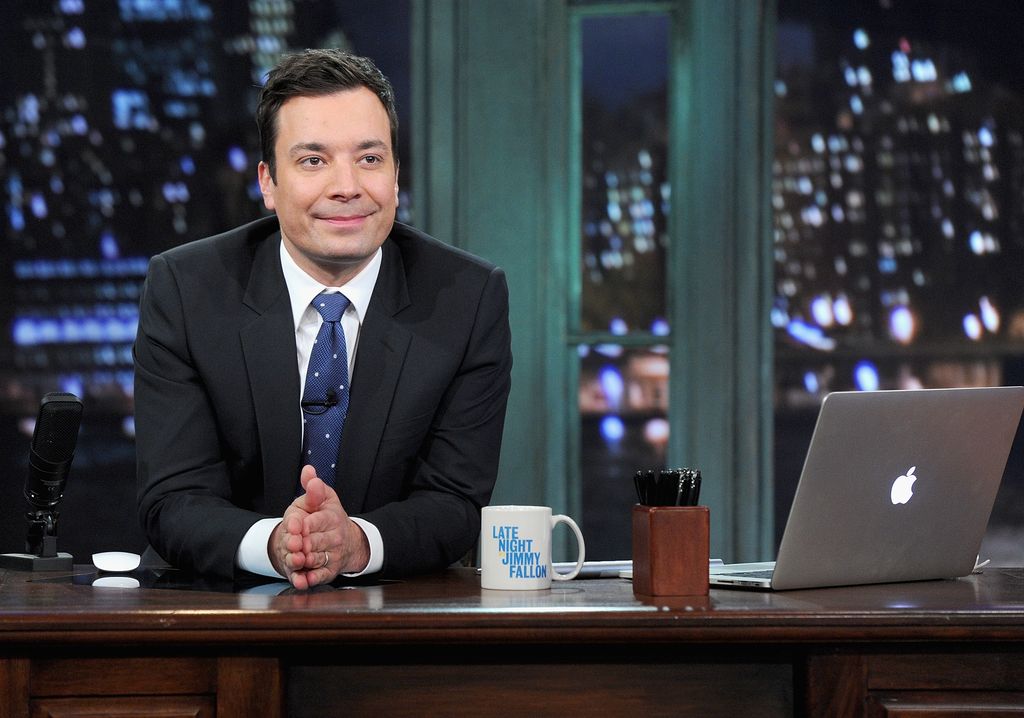  Jimmy Fallon sits behind a desk on Late Night with  Jimmy Fallon 