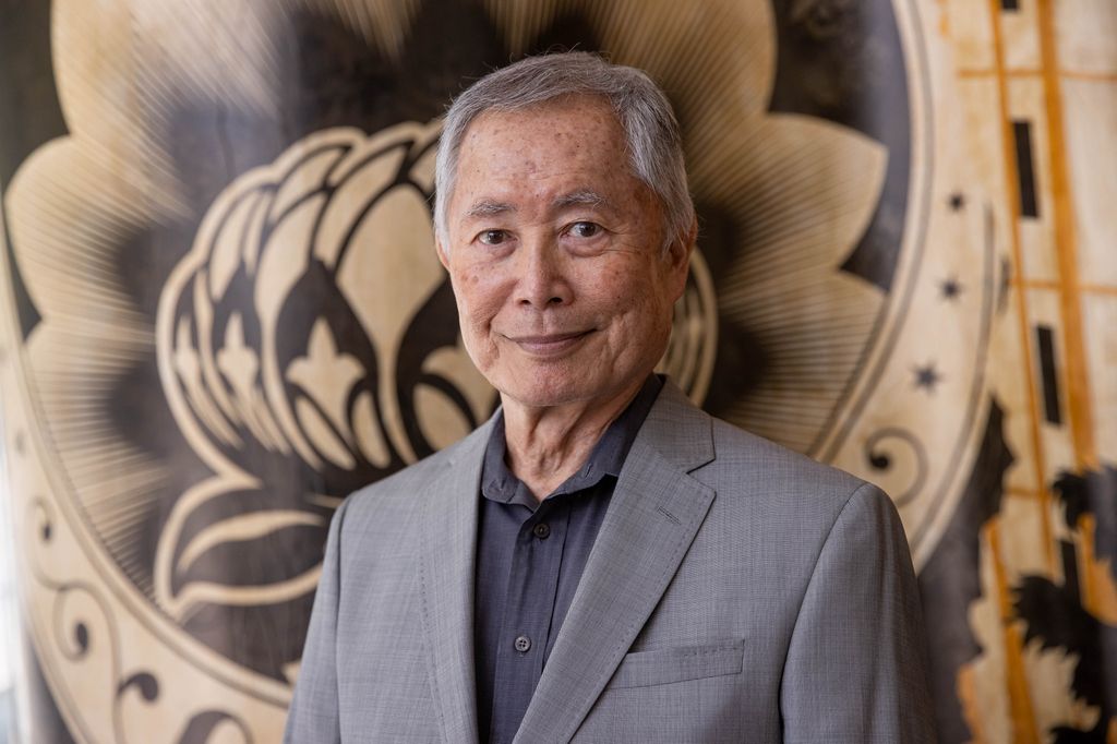 George Takei souriant dans un costume 