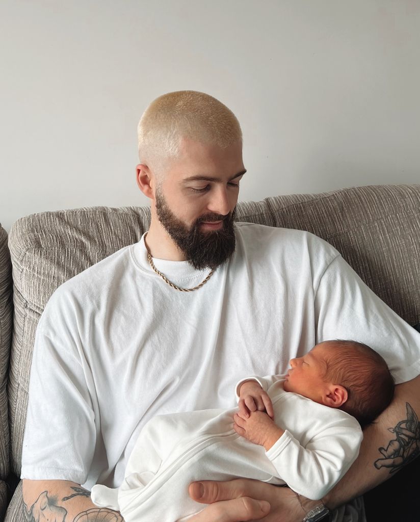 uncle cradling baby nephew on sofa