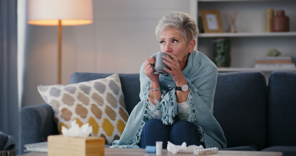 ill woman under blanket on sofa