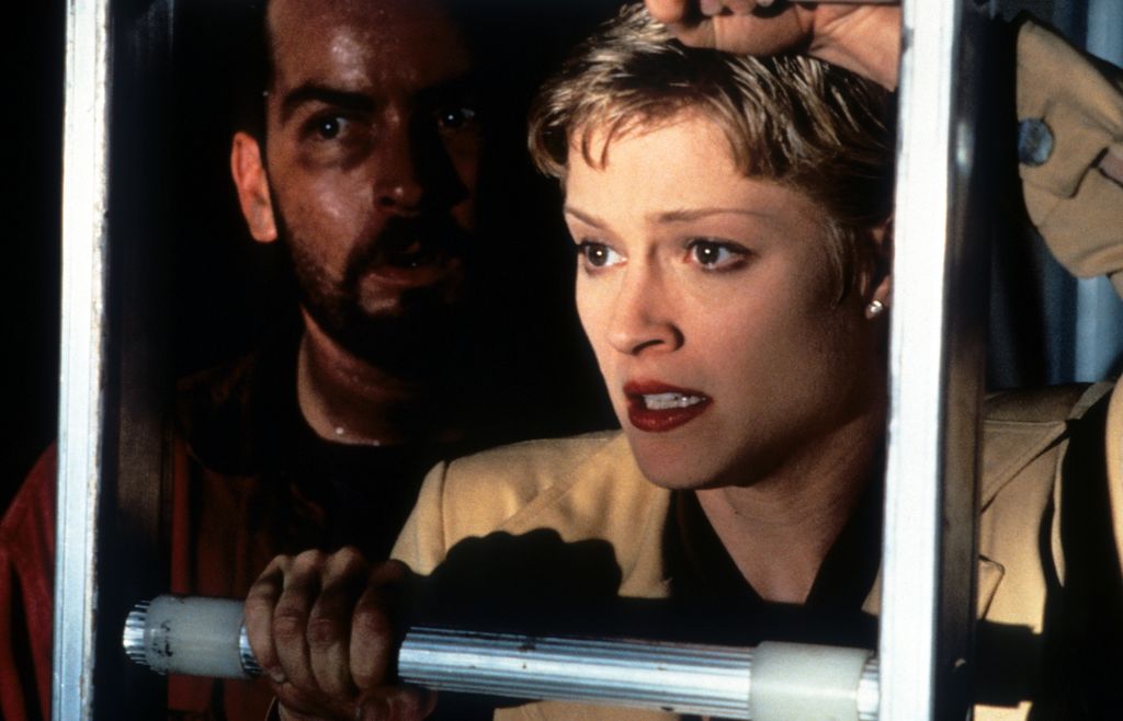 Charlie Sheen regarde derrière des barres métalliques à côté de Charlie Sheen.