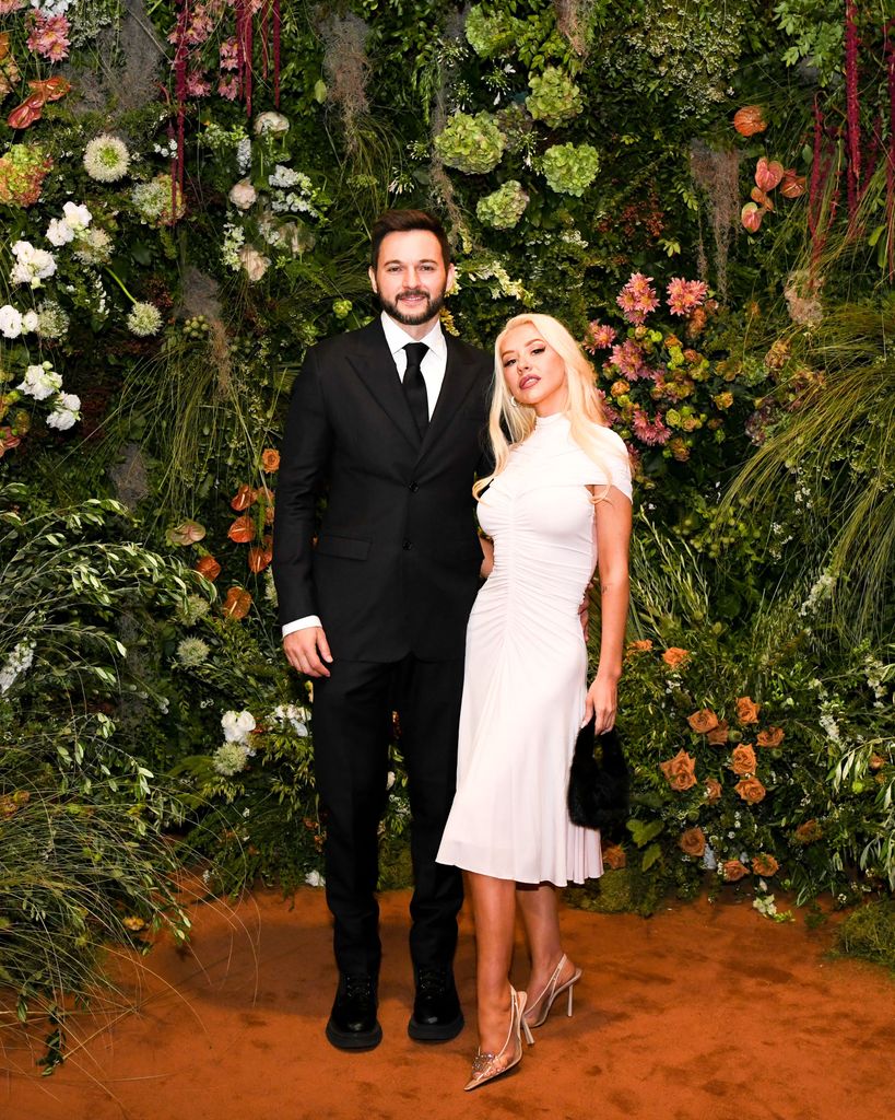 Christina Aguilera and Matthew Rutler pose in front of plants and trees
