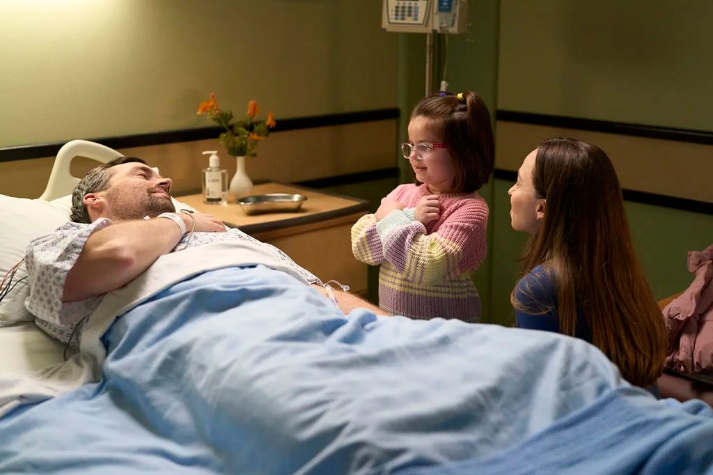 Still from Ripple with Ian Harding laying in a hospital bed