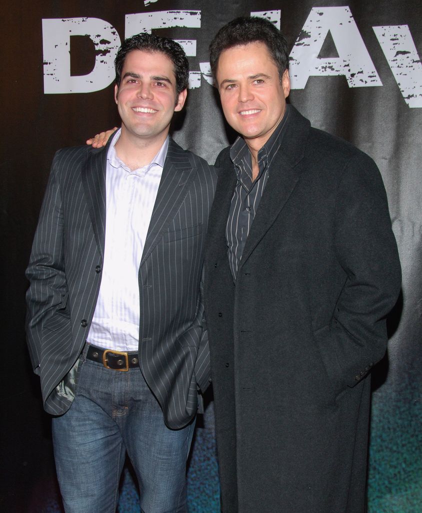 Don Osmond Jr. and Donny Osmond wraps an arm around him smiling at "Deja Vu" New York Premiere