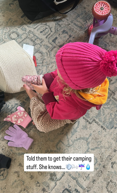 young girl sitting on floor with pink hat on 