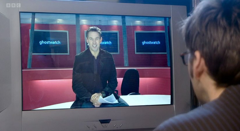 Man watching tv screen with tv host in studio