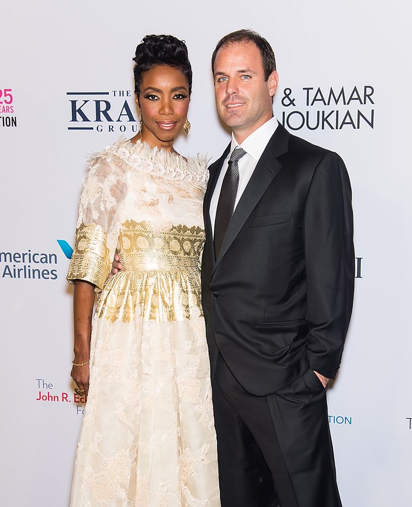 Heather Headley wearing a white dress and her husband Brian Musso, dressed in a suit