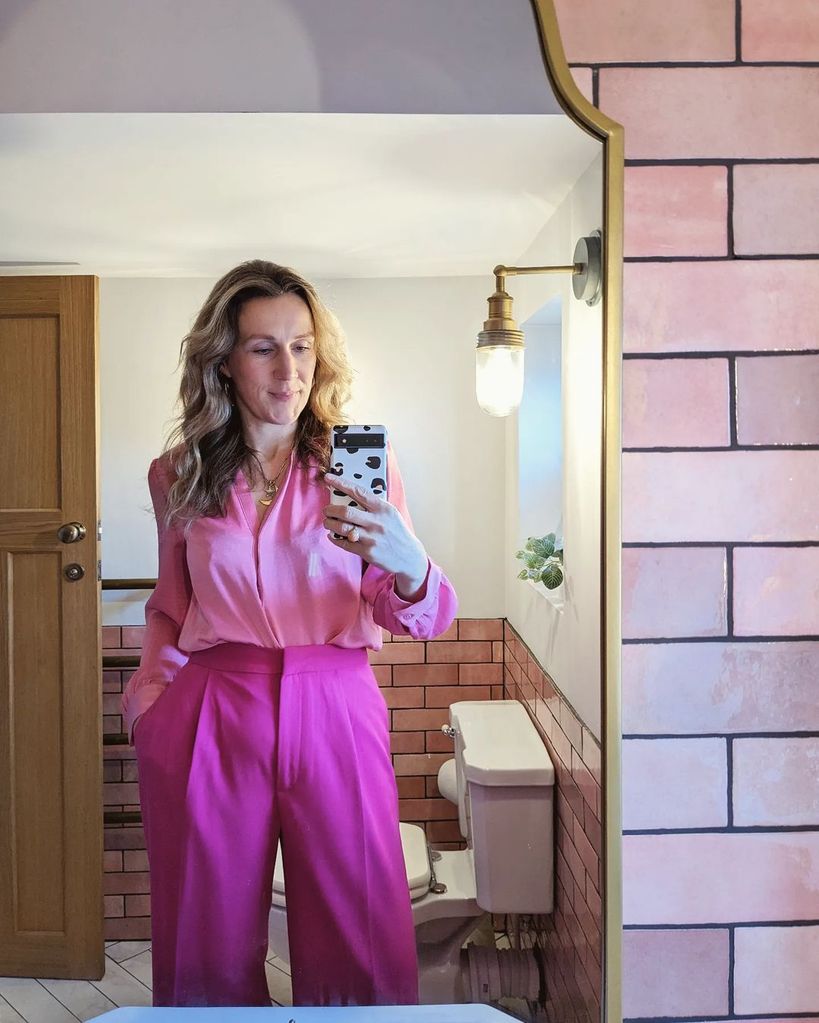 Woman in pink taking a selfie in the mirror