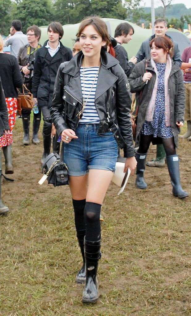 Alexa Chung in a Breton top with denim shorts and a leather jacket, as well as feline flick eyeliner.