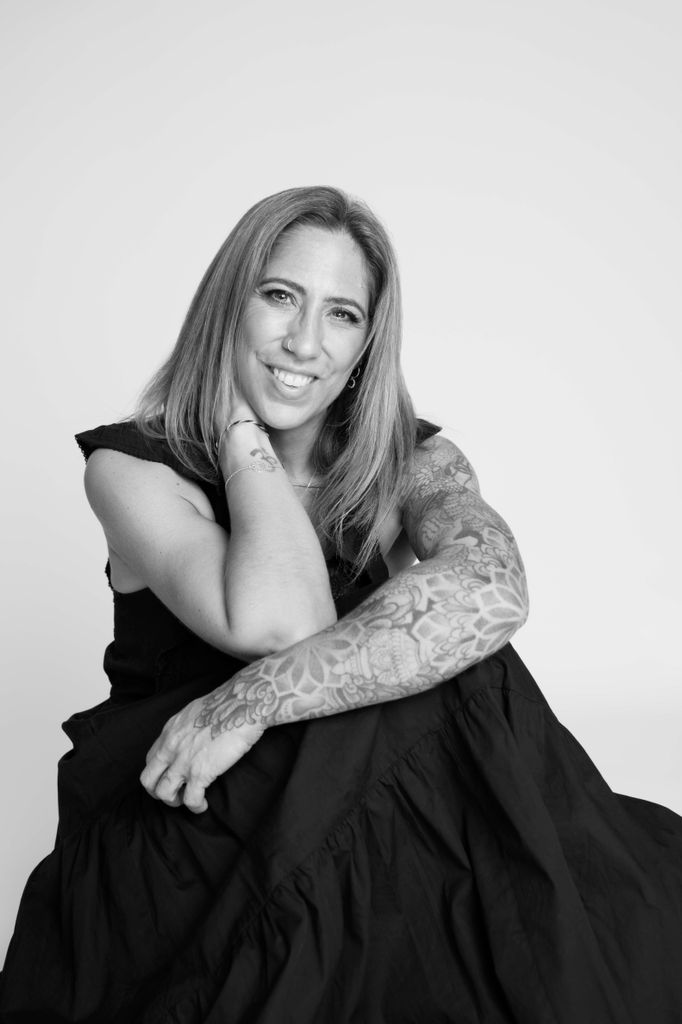 A black and white image of Kirsty smiling at the camera 