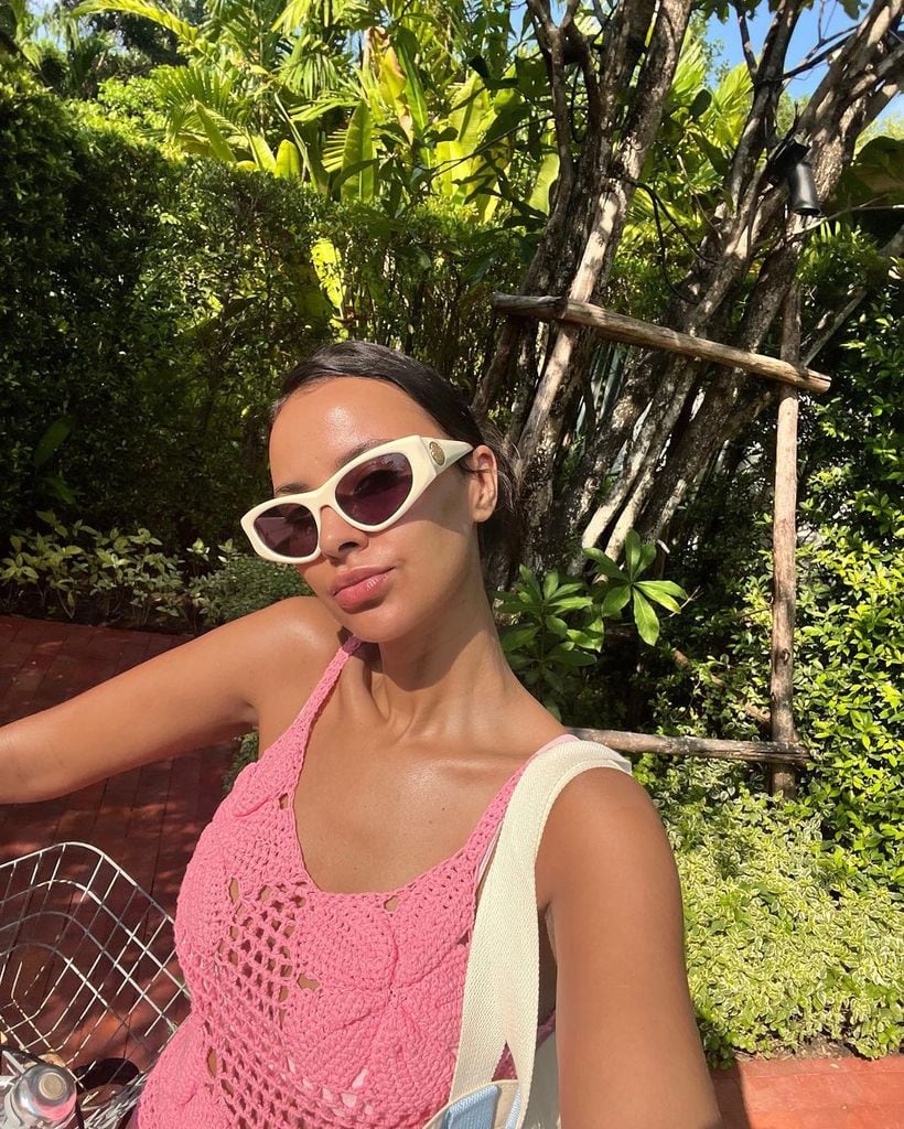 maya jama wearing pink crochet top and white sunglasses
