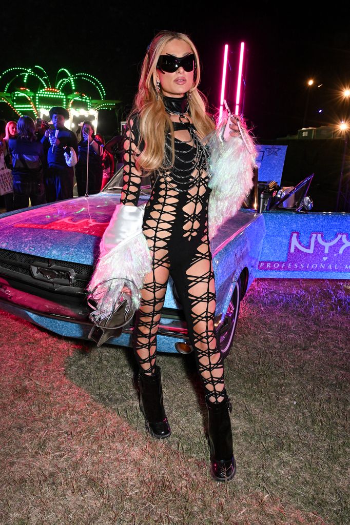 Paris Hilton at NEON Carnival on April 12, 2025 in Thermal, California in a black cutout cat suit