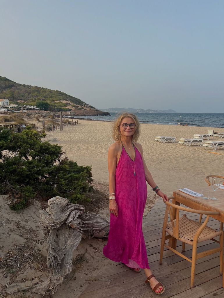 Woman in her 50s in a pink dress on the beach in Ibiza 