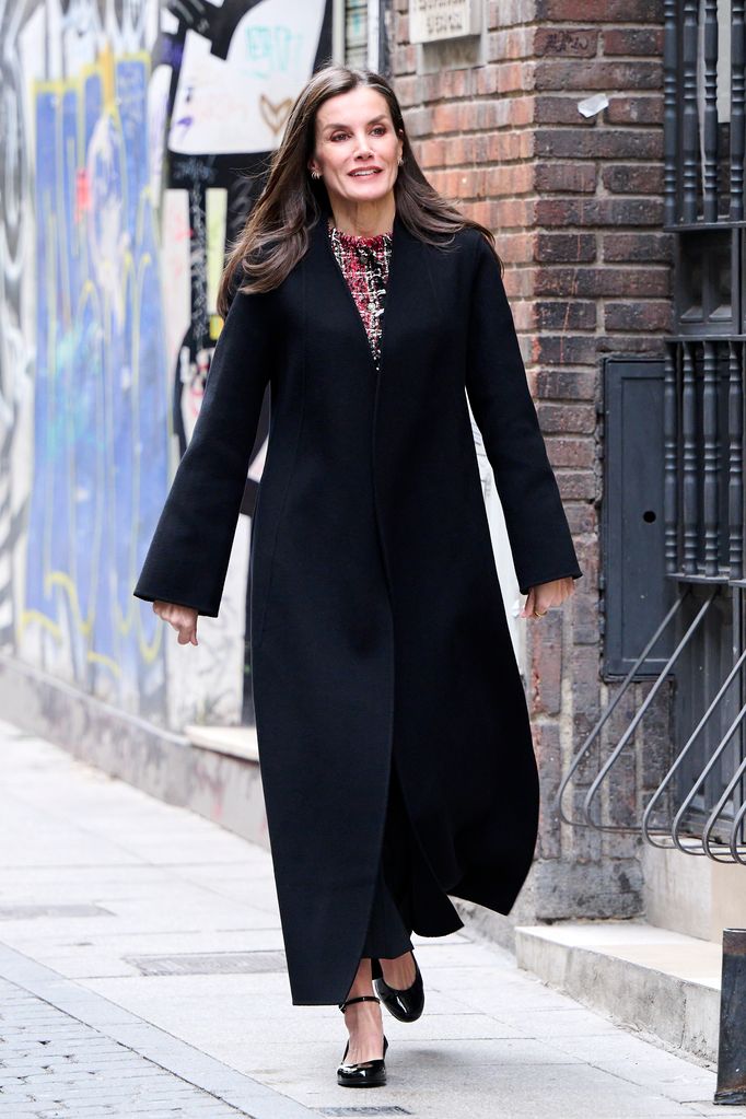 Queen Letizia of Spain wears a long black coat and a pair of patent ballet flats while walking down the streets of Madrid