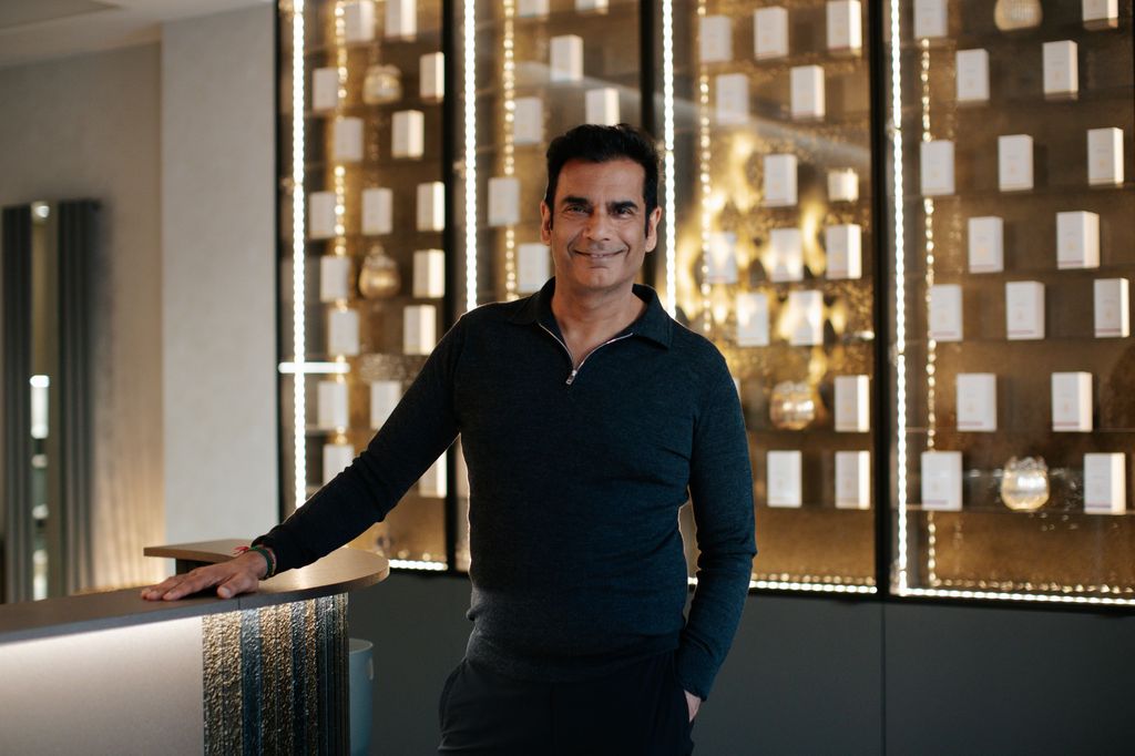 smart man in front of a window with gold behind him 