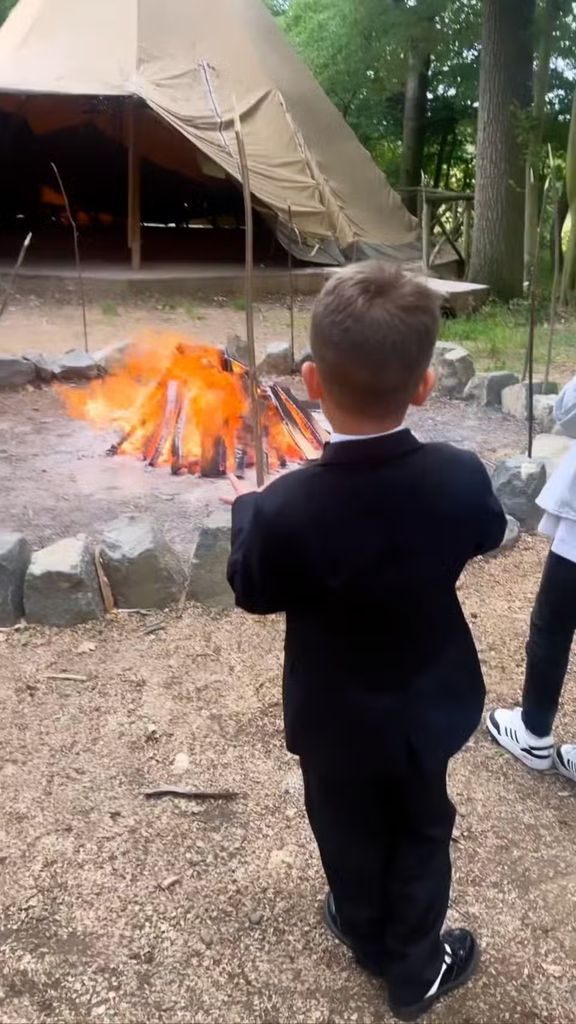 boy in front of campfire