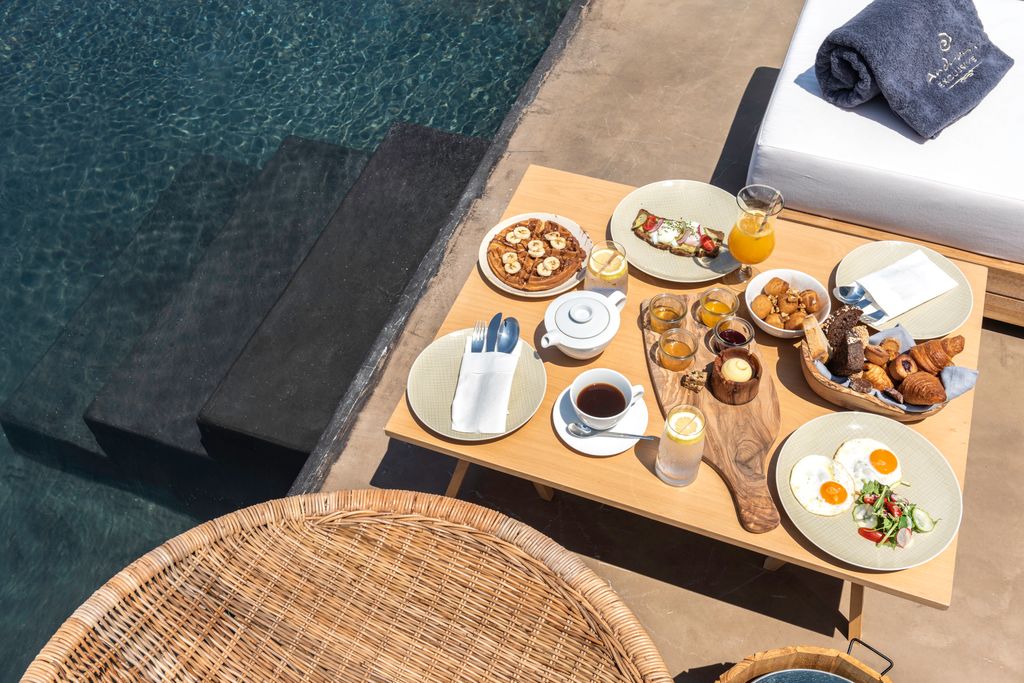 breakfast laid out on table next to swimming pool
