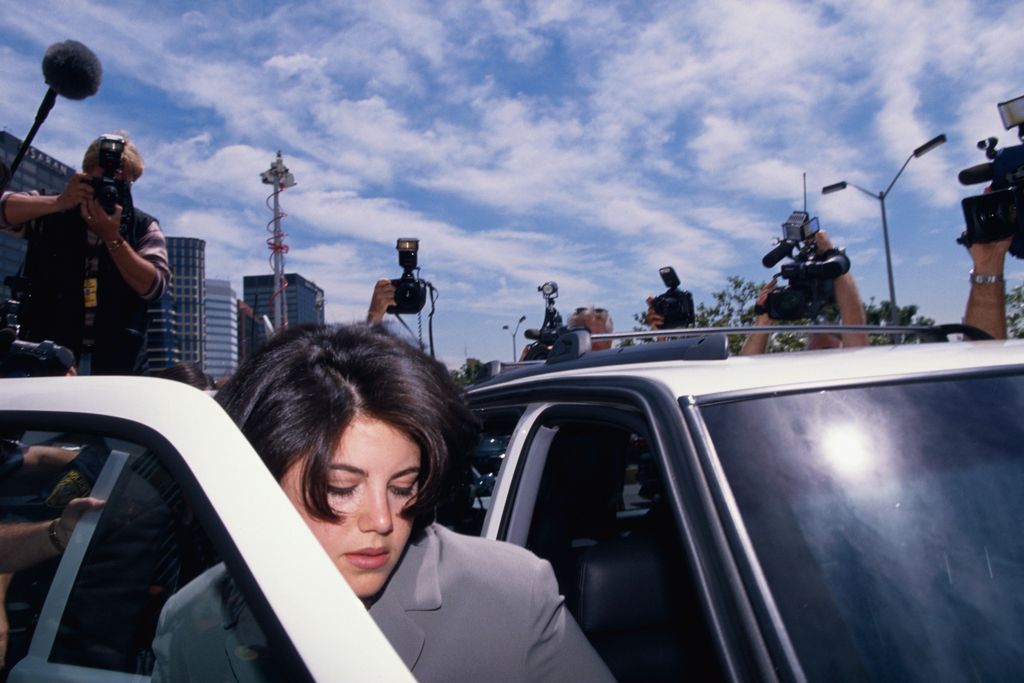 Monica Lewinsky surrounded by photographers as she gets into car. Lewinsky is on her way to the FBI Headquarters, May 1998