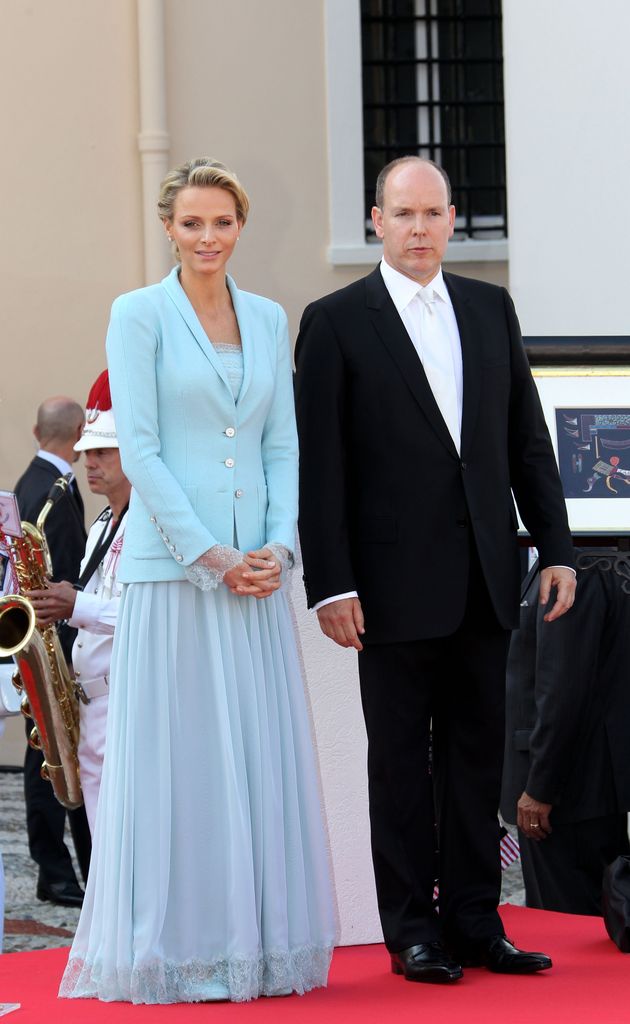 Princess Charlene in blue blazer and skirt and Prince Albert in suit