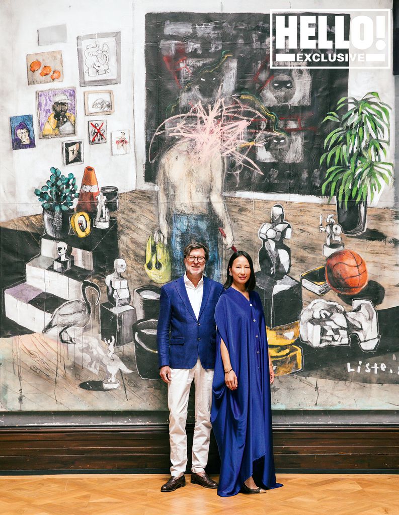 Couple standing in front of mural in blue outfits