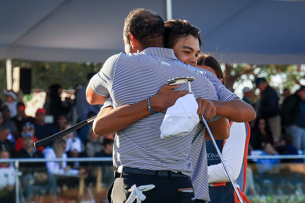 Charlie Woods hugs his father Tiger Woods on the 18th hole green after their first round of the PNC Championship at Ritz-Carlton Golf Club on December 21, 2024 in Orlando, Florida