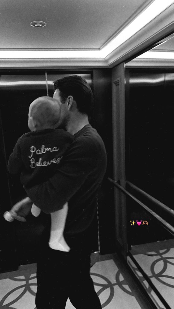 Mark wright carrying baby in elevator in black and white photo