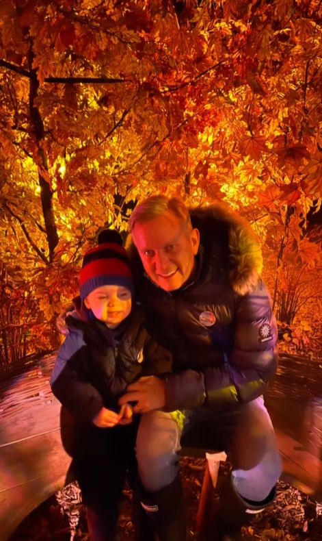 Jeremy Kyle and a young boy surrounded by autumn leaves