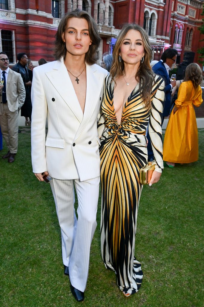 Damian Hurley in a white suit and Elizabeth Hurley in an animal-print dress