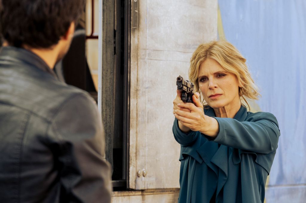 blonde woman pointing gun at man