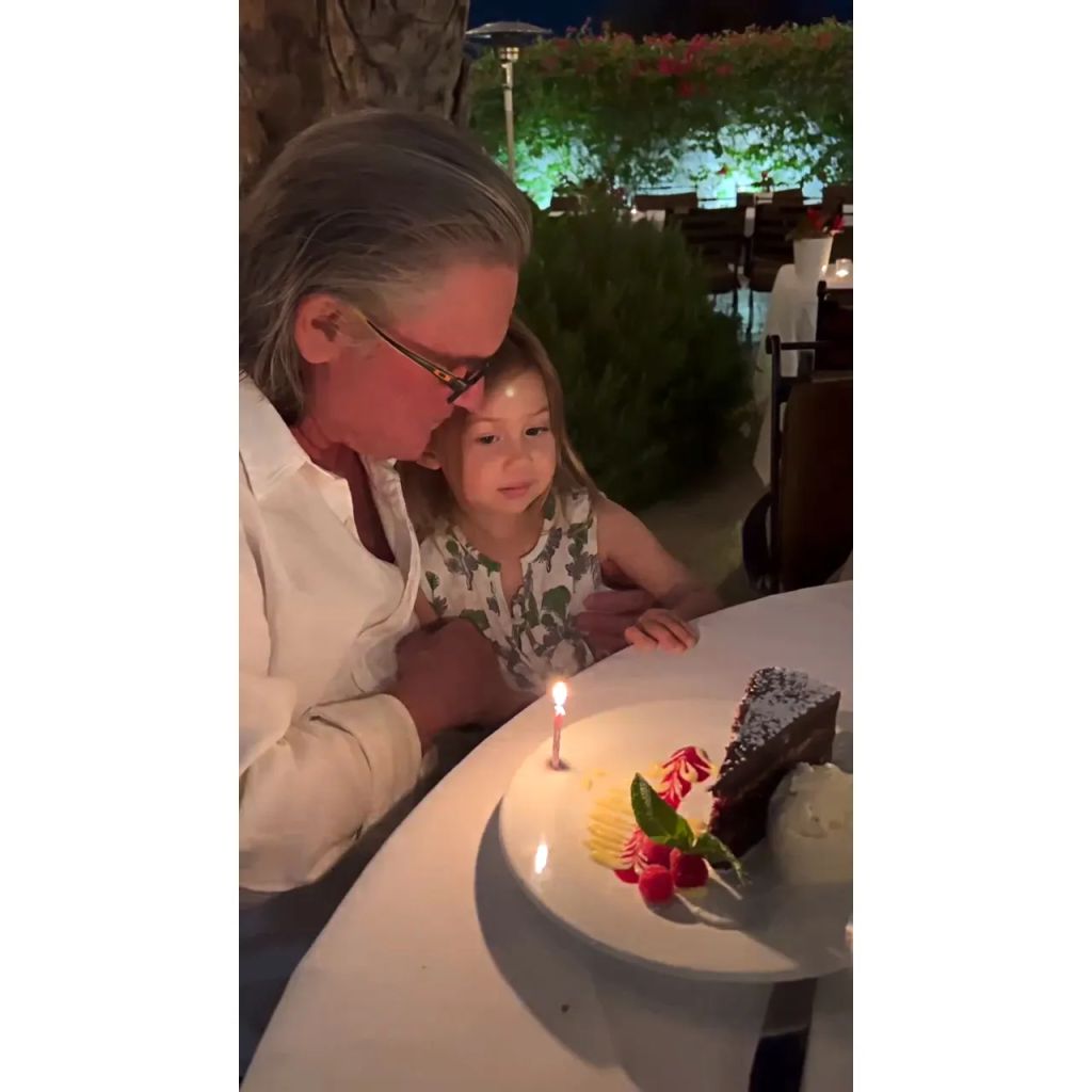 Kurt Russell sits with granddaughter Rani in front of a plate of dessert and a birthday candle