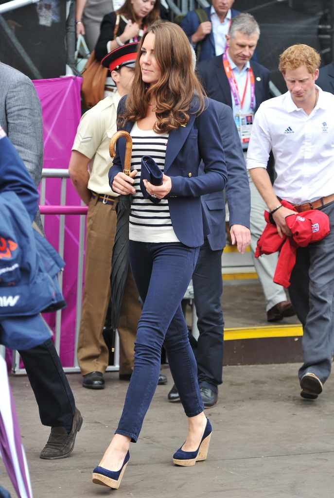 Kate walking through crowd in jeans and striped top
