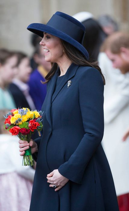 kate middleton touches baby bump in blue