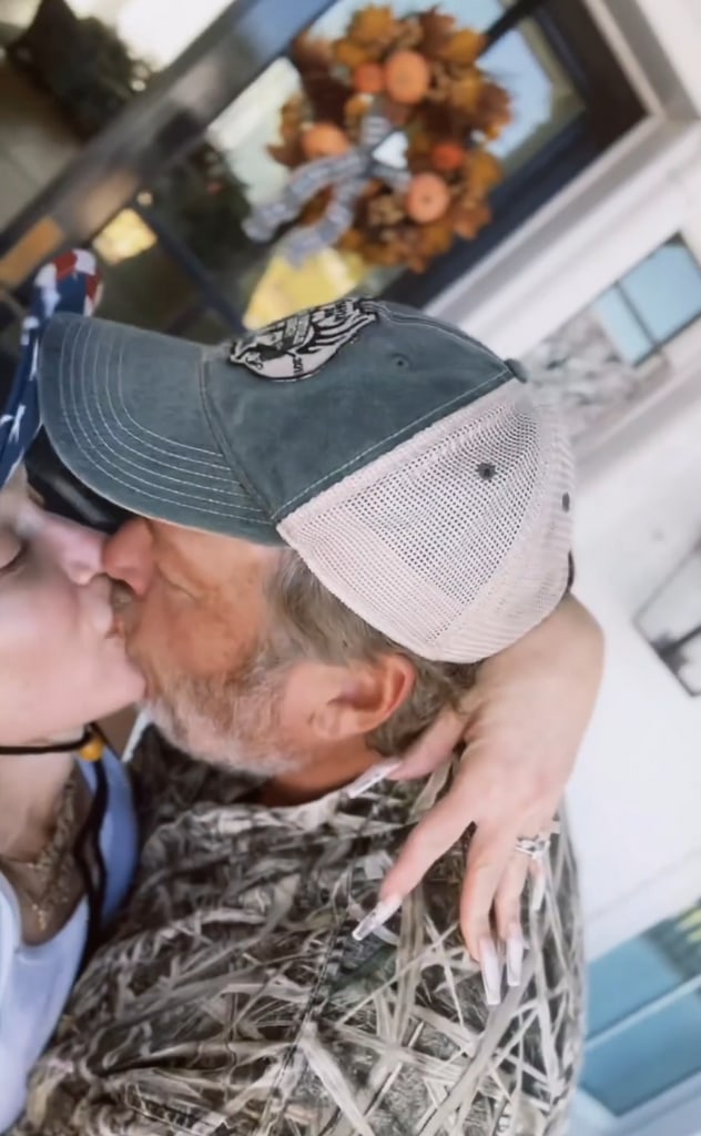 Still from a video shared by Gwen Stefani of her and Blake Shelton sharing a kiss as they worked on decorating their Oklahoma home with fall decorations harvested from their ranch.