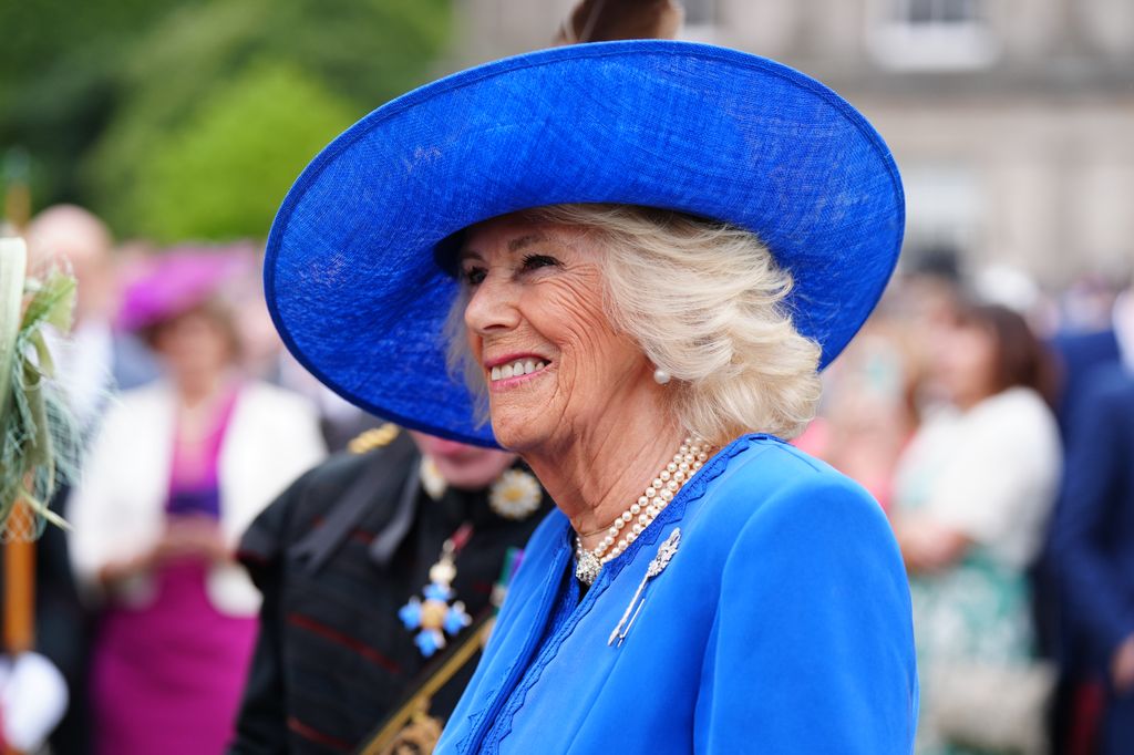 Queen Camilla wearing Diamond Thistle Brooch on blue coat